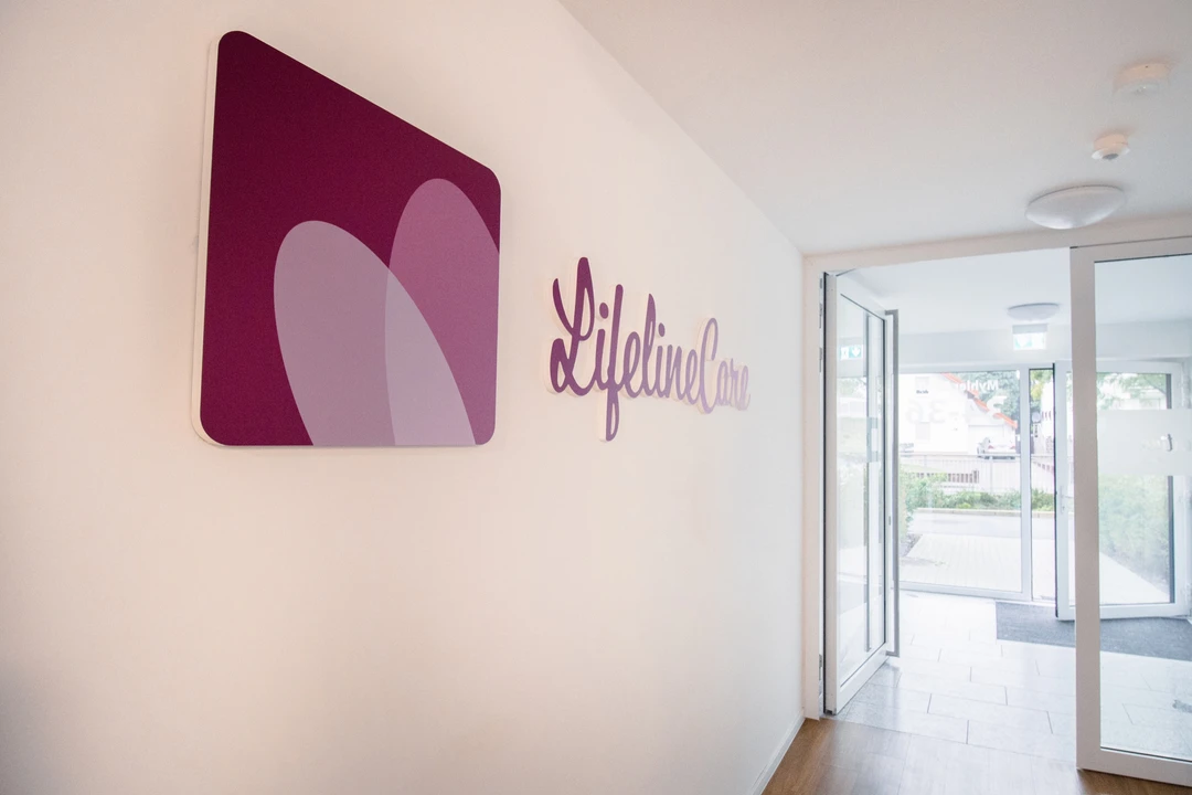 Logo und Schriftzug von Lifeline Care an der Wand im Eingangsbereich